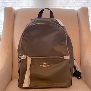 Brand new w/tags, authentic moss green Coach backpack with gold zipper detail.